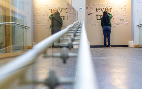 a student stands at a memorial wall